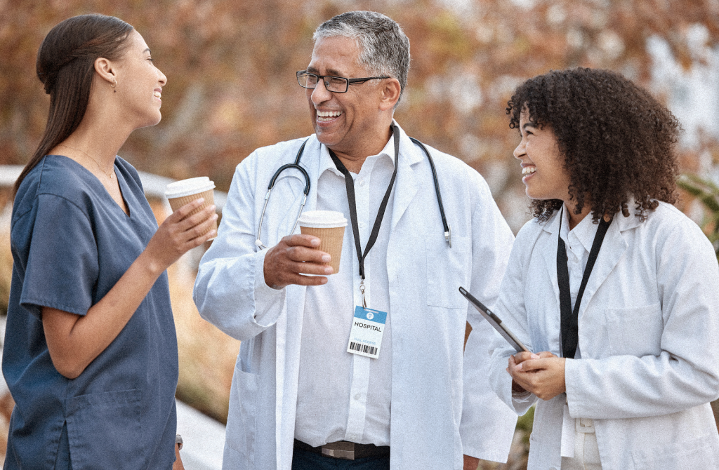 Doctors on break chatting outside with coffee.