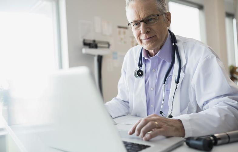 Male physician on laptop