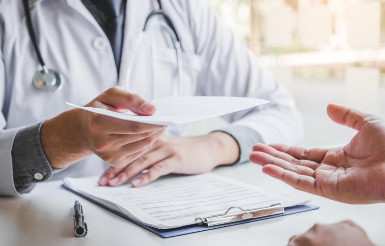 Physician handing prescription to patient 