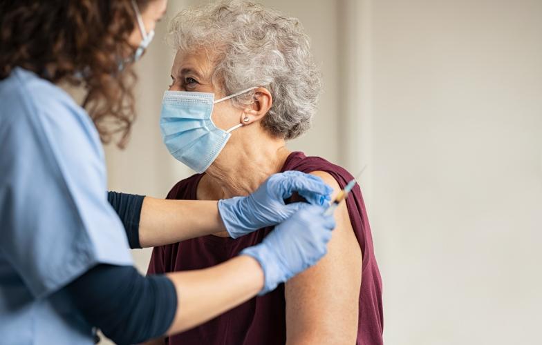 Doctor providing elderly woman COVID vaccine 