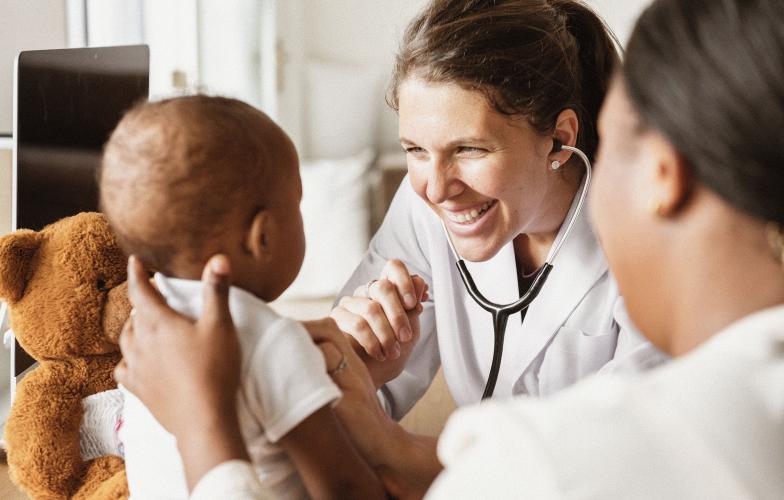A young doctor examining a baby.
