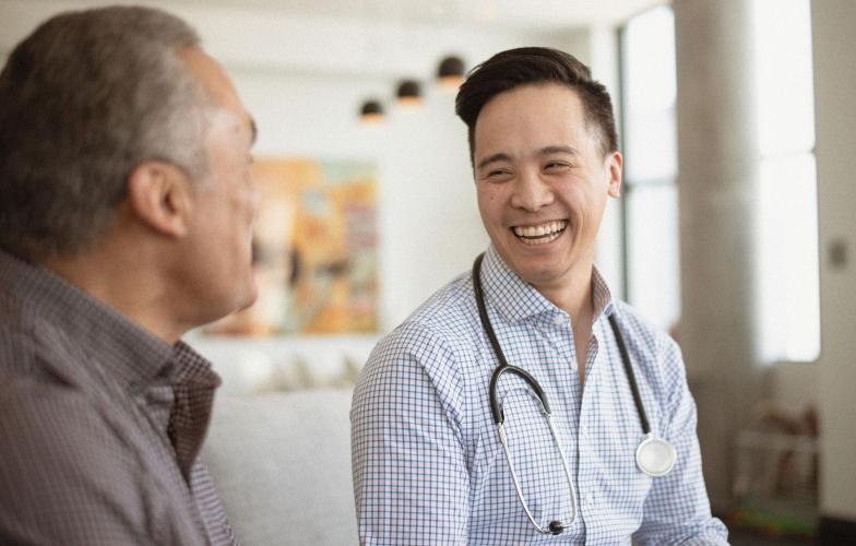 A doctor laughing with their patient.