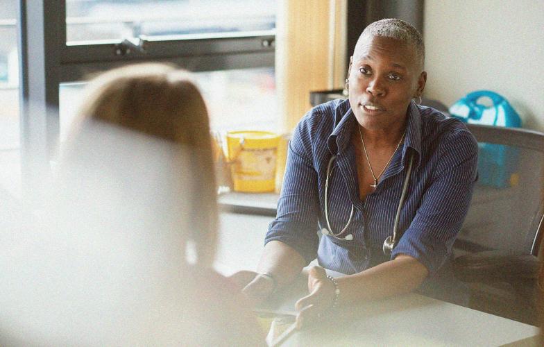 A doctor speaking to a patient in their office. 