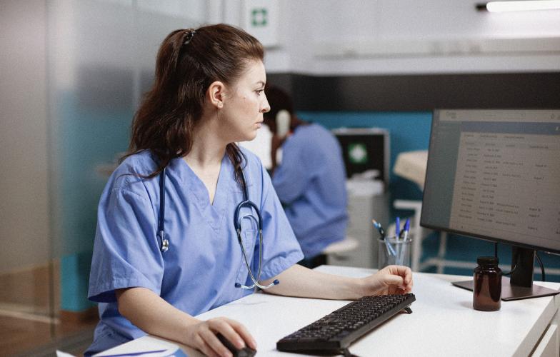 A doctor looking at an MRI on a screen in a clinic. 