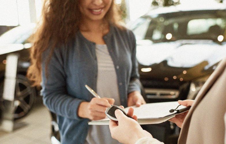 Person at a rental car location signing paperwork.
