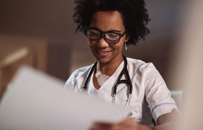 A doctor looking over paperwork and smiling. 