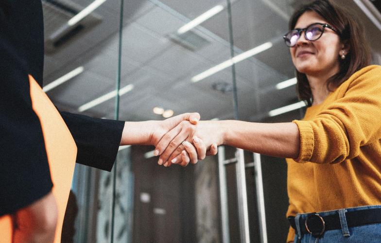 Two people shaking hands in an office.