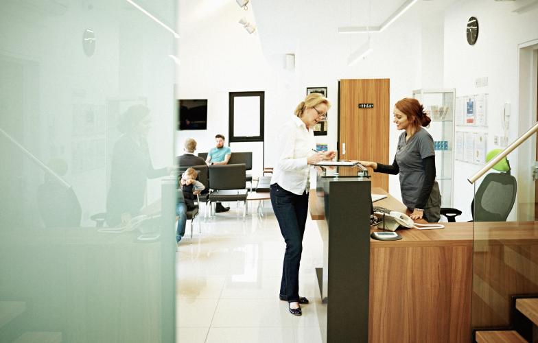 person at reception desk in doctors office