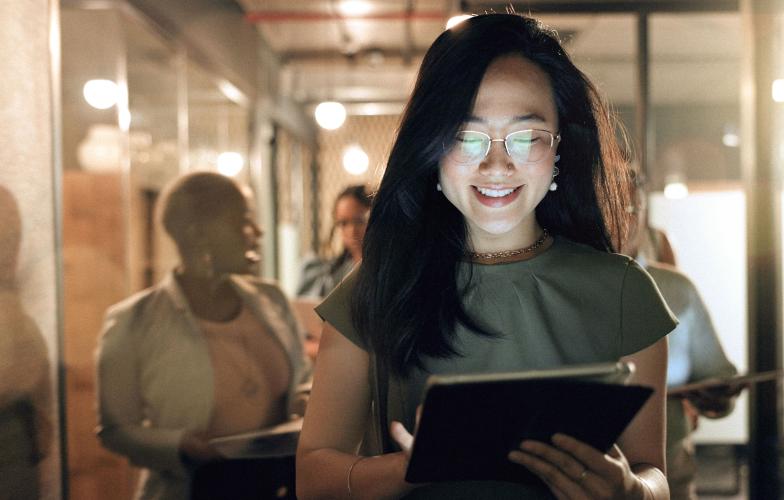 a health care worker looking at an iPad in an office