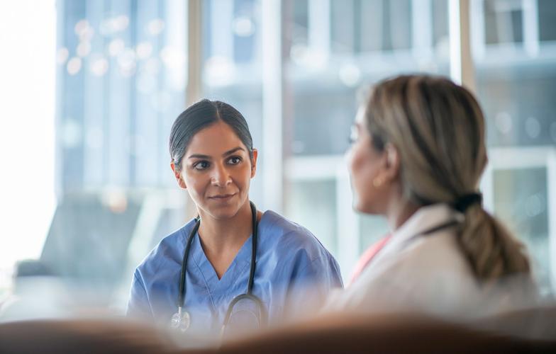 a BIPOC heath care working talking with a colleague