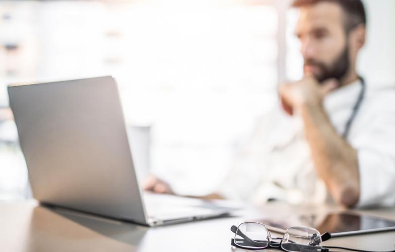 physician looking at a lap top