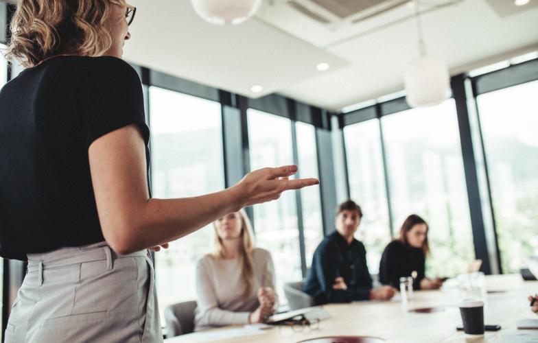 Business woman presenting to colleagues in board room.