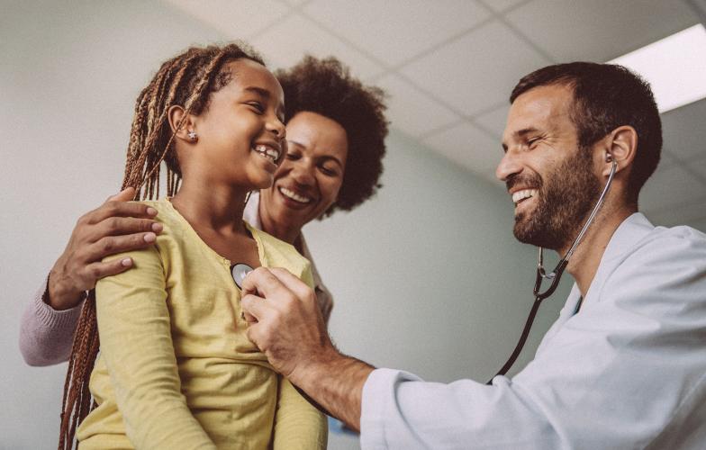 A doctors examines a young patient's heart