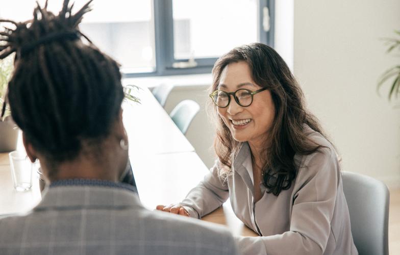 Woman talking to colleague in a board room.