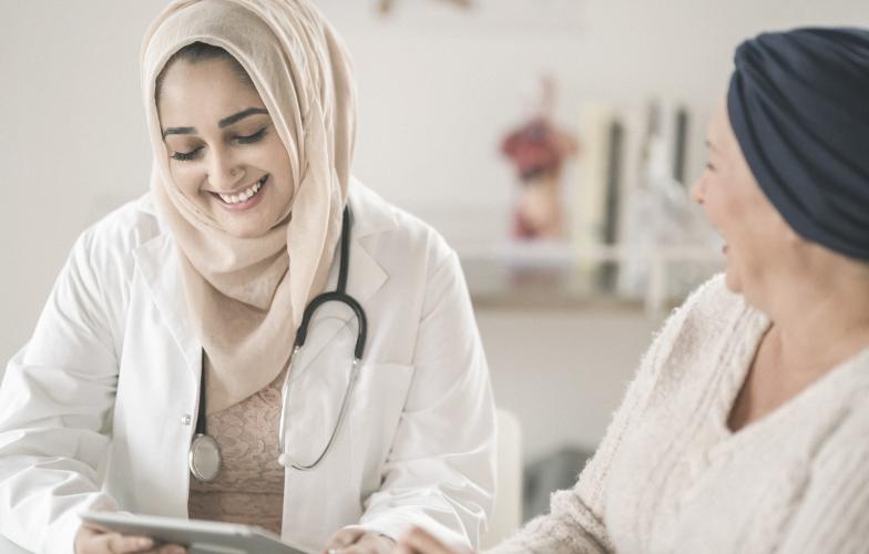 Doctor smiling looking at laptop.