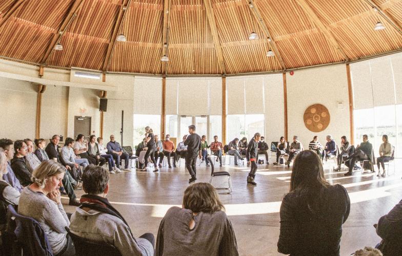 A circle of people participating in a Musqueam First Nations community-based learning session