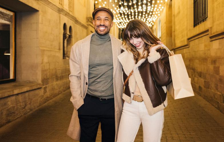 Two people shopping at night on a street.