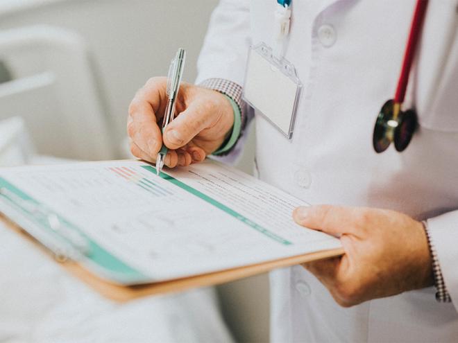 Doctors writing on clipboard.