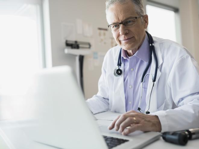 Male physician on laptop