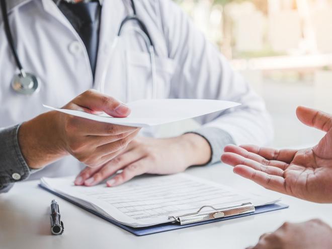 Physician handing prescription to patient 