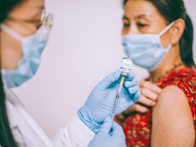 Asian woman receiving COVID-19 vaccine