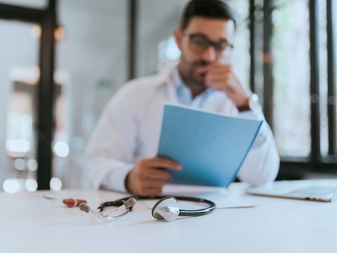 physician_blurry_out_of_focus_at_desk_stethoscope_patient_file_stock_photography_1.jpg
