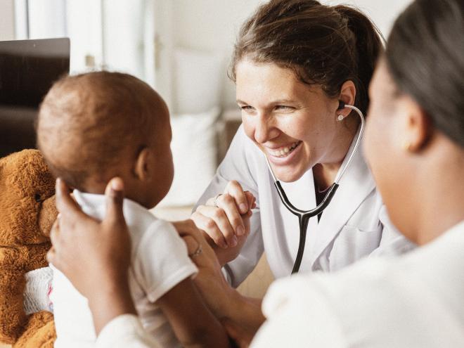 A young doctor examining a baby.