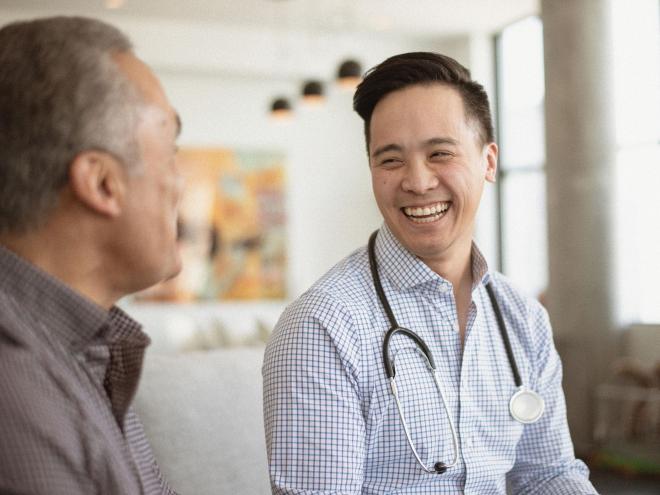 A doctor laughing with their patient.
