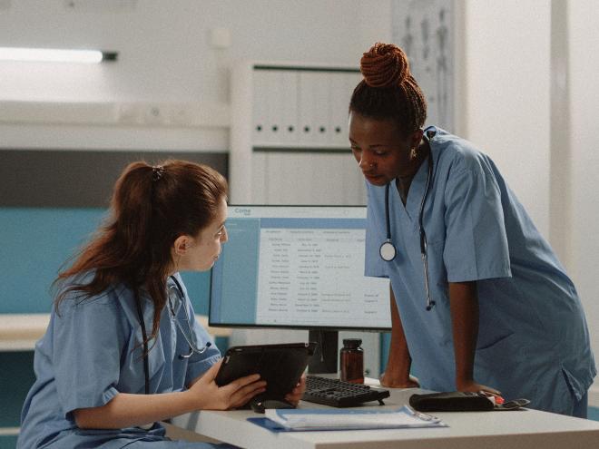 Two doctors looking at a patients chart in a clinic.