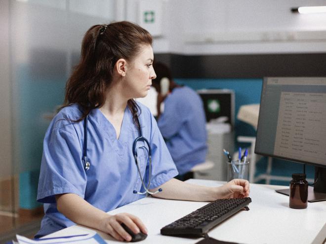 A doctor looking at an MRI on a screen in a clinic. 