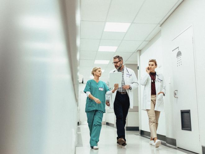 A group of doctors walking down a hospital hallway.