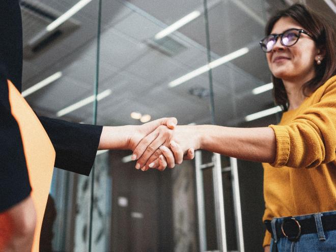 Two people shaking hands in an office.