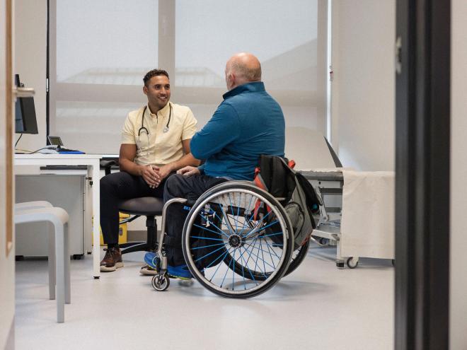 family doctor with patient in wheelchair