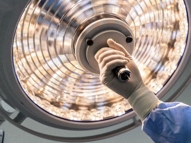 close up of surgeon hand holding surgical lamp