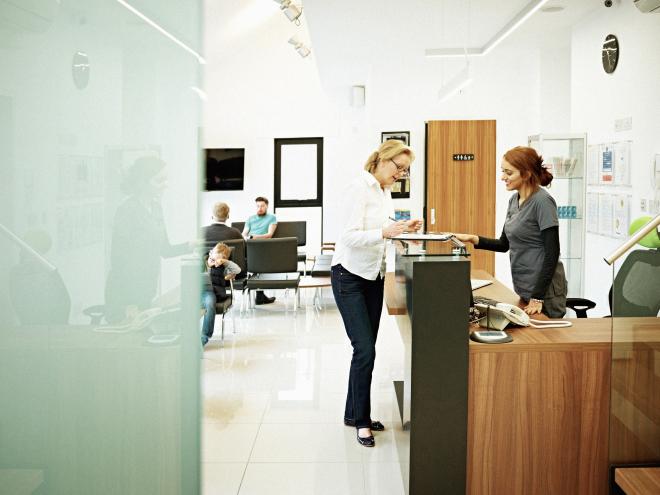 person at reception desk in doctors office