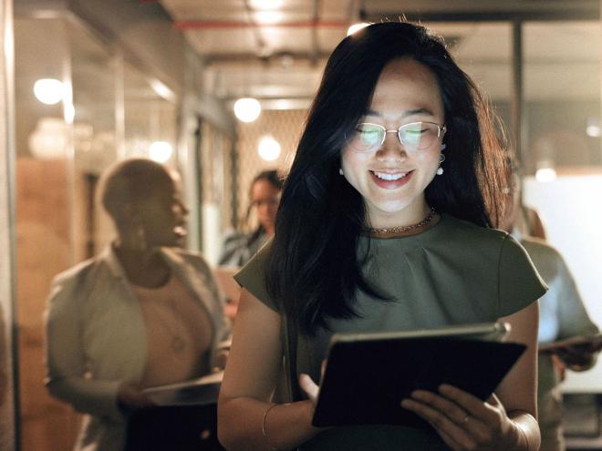 a health care worker looking at an iPad in an office
