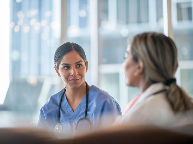 a BIPOC heath care working talking with a colleague