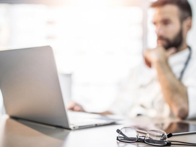 physician looking at a lap top