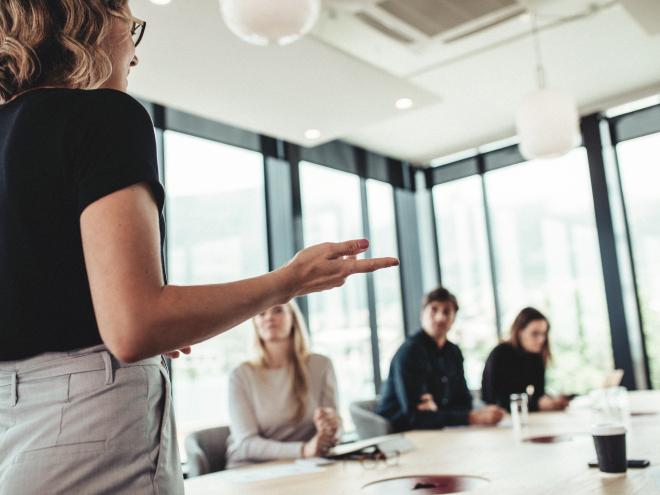 Business woman presenting to colleagues in board room.