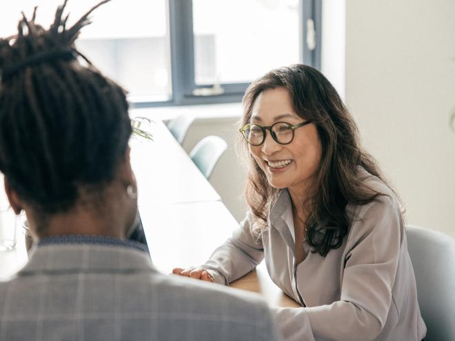 Woman talking to colleague in a board room.