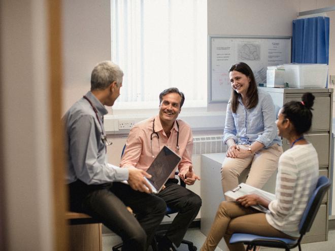 A group of family doctors conversing in a clinical setting