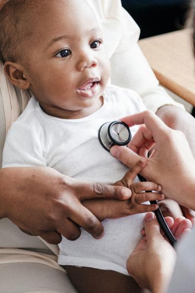 A doctor examining an infant's heart with stethoscope.