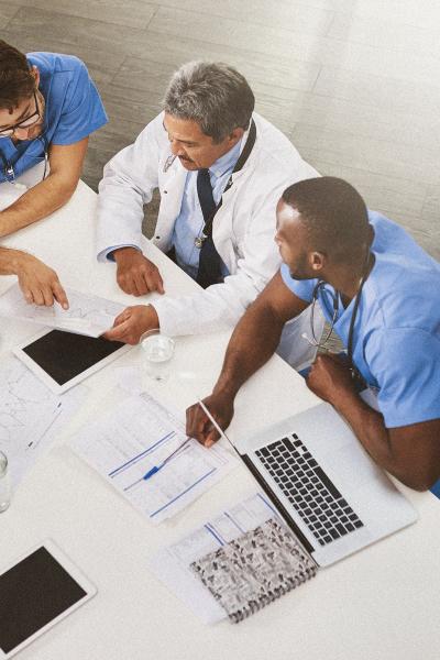 A group of doctors reviewing documents sitting at a table.
