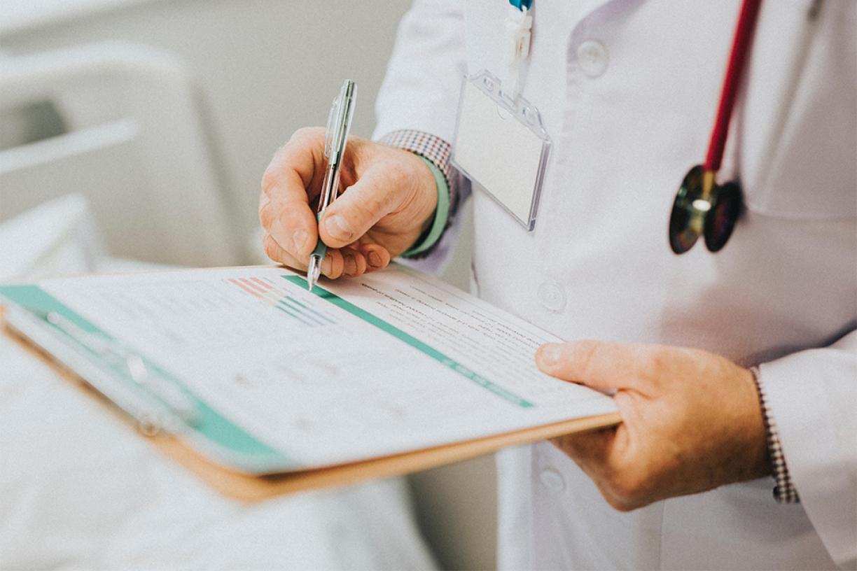 Doctors writing on clipboard.
