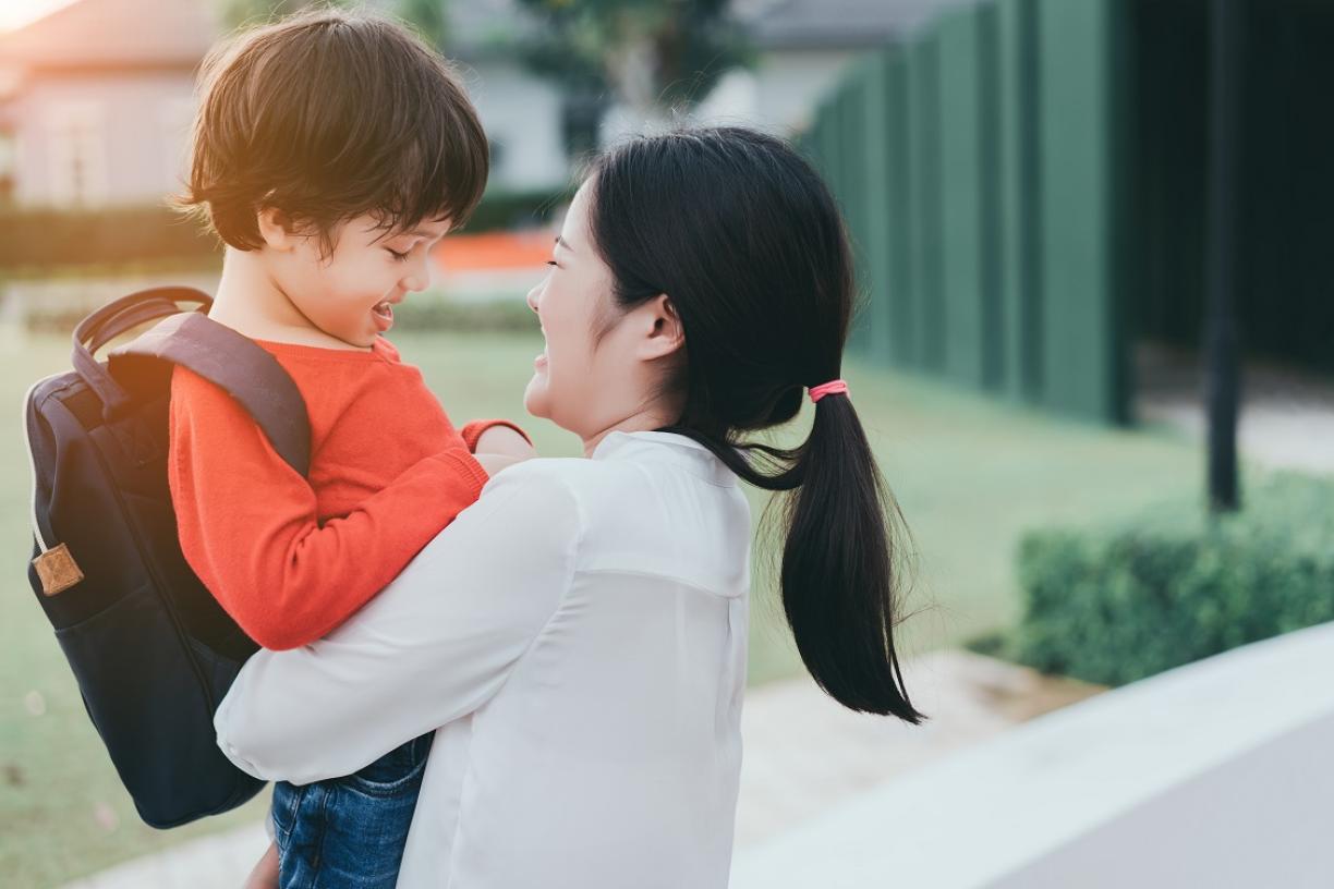 Mom holding child with backpack