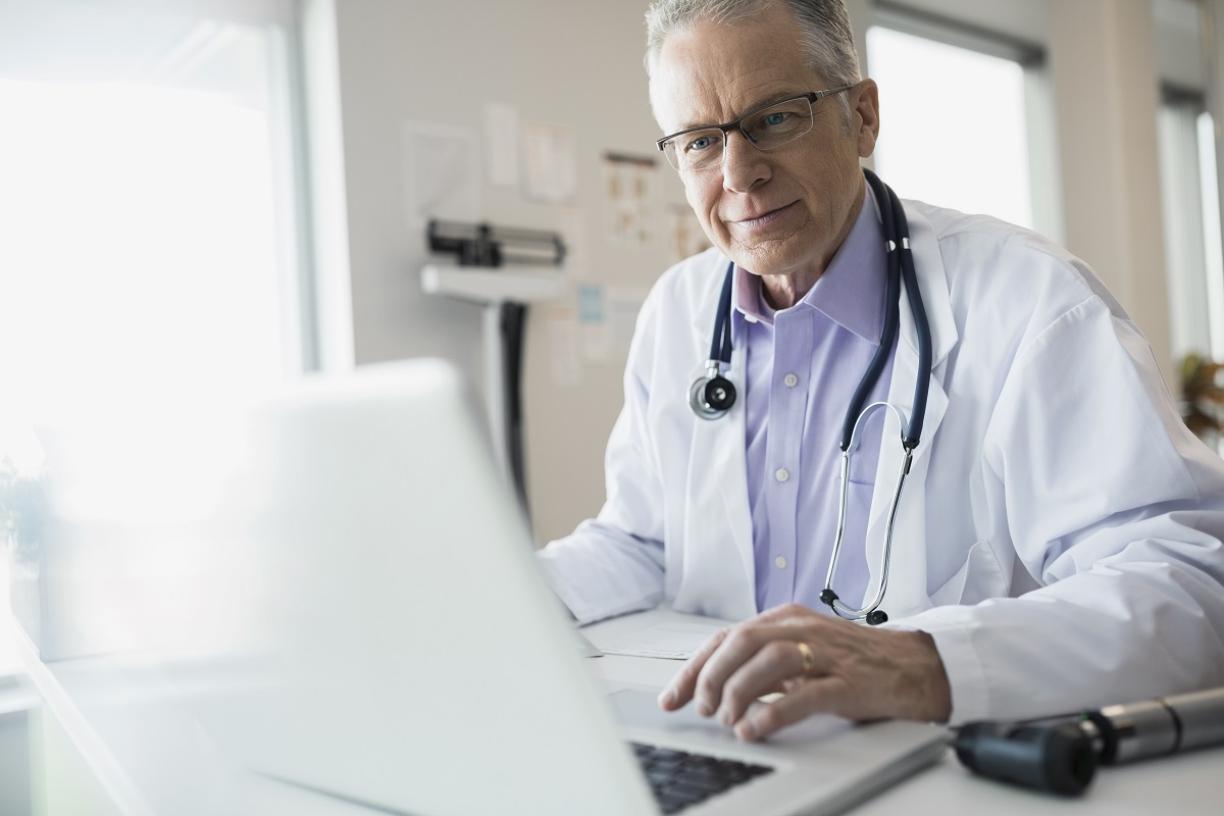 Male physician on laptop