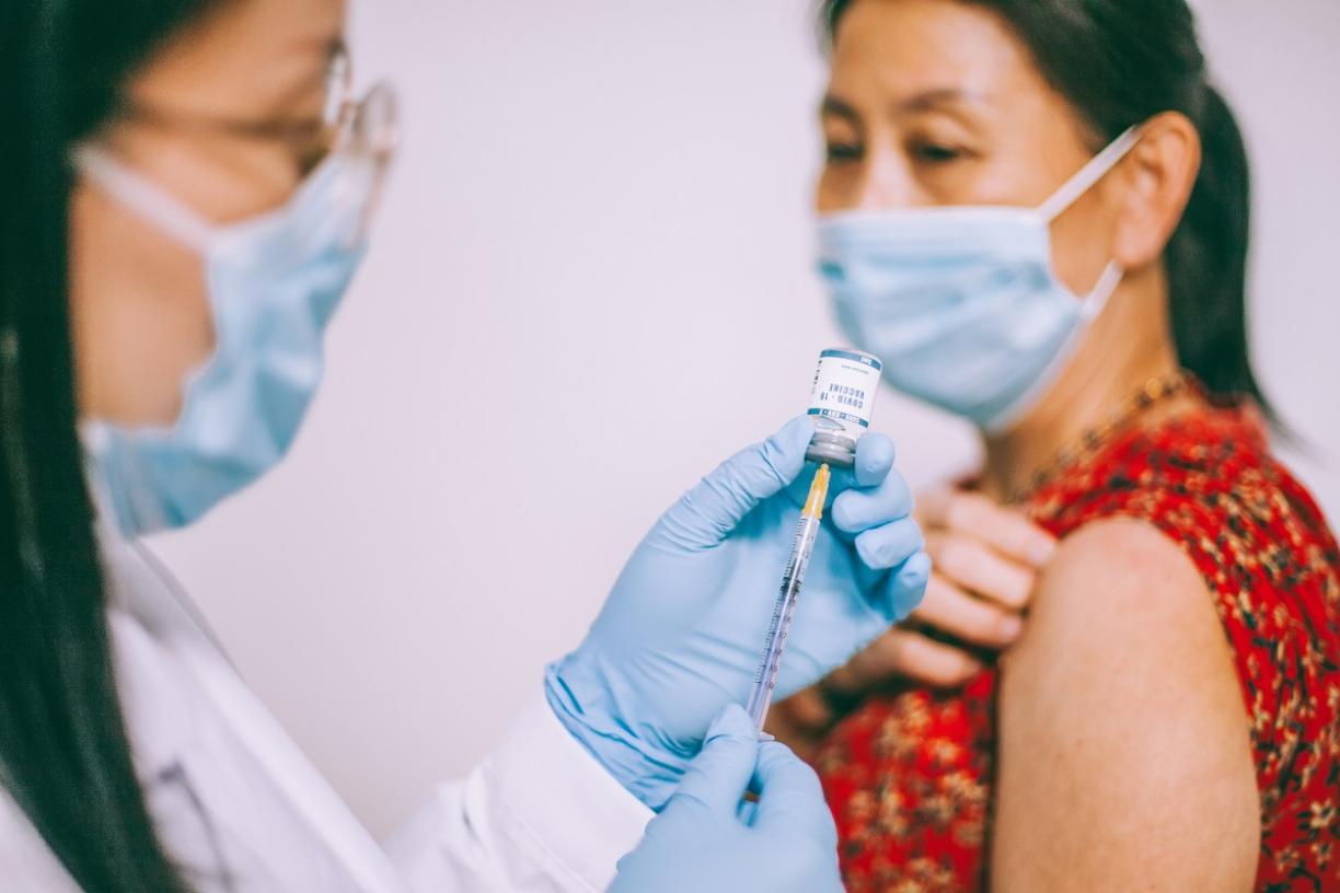 Asian woman receiving COVID-19 vaccine