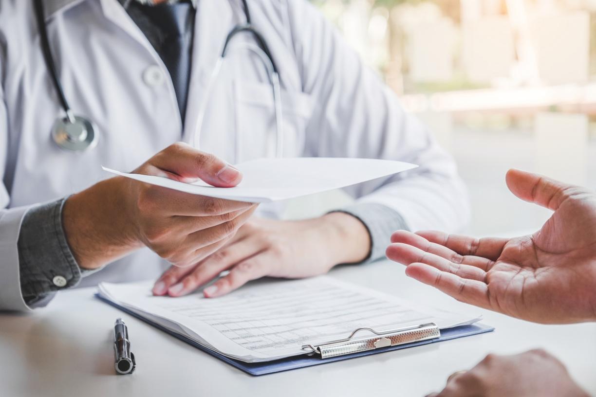 Physician handing note to patient