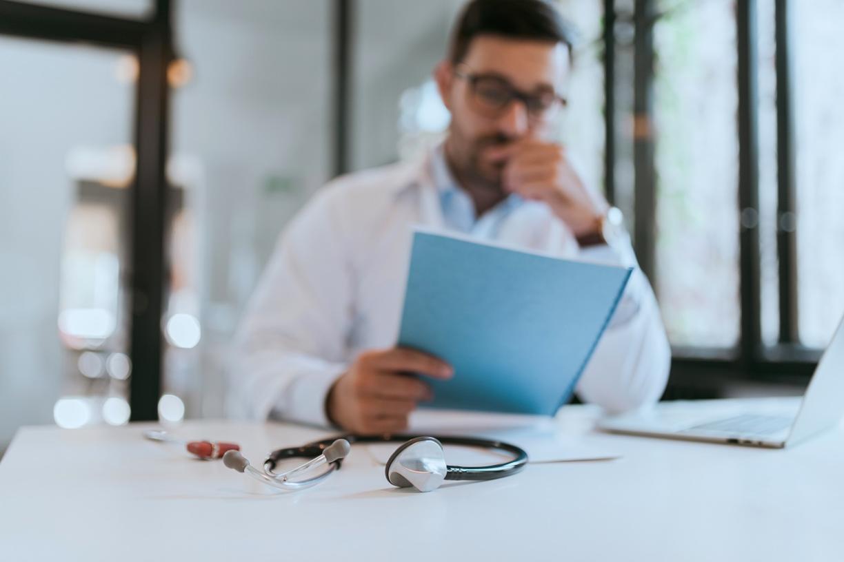 physician_blurry_out_of_focus_at_desk_stethoscope_patient_file_stock_photography_1.jpg