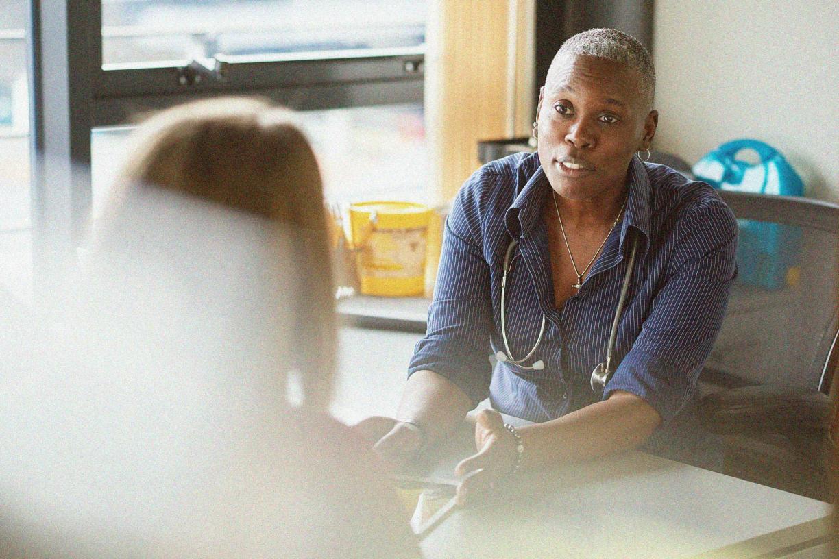 A doctor speaking to a patient in their office. 
